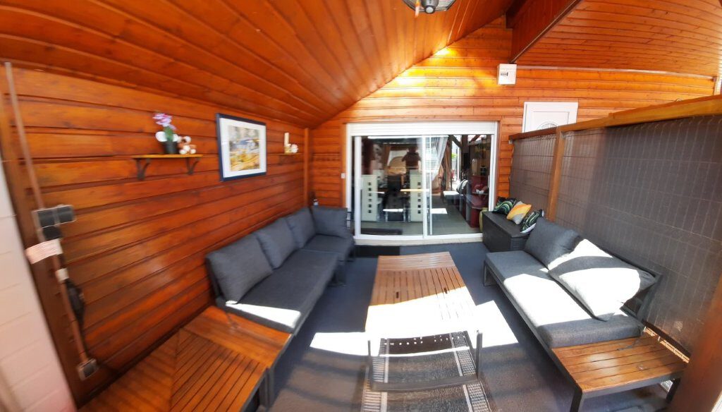 Terrasse couverte du chalet, salon extérieur en bois pour se retrouver