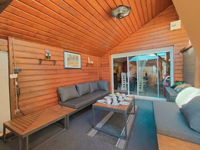 Salon extérieur sous la pergola, avec télévision