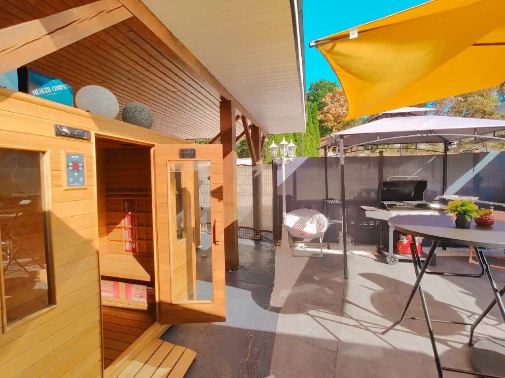 Spa extérieur chauffé et cabine sauna sur la terrasse du chalet